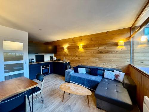 un salon avec un canapé bleu et une table dans l'établissement Appart 313, au pied des pistes de ski avec superbe vue, à La Bresse