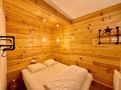 une chambre avec un lit dans un mur en bois dans l'établissement Appart 313, au pied des pistes de ski avec superbe vue, à La Bresse
