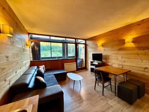un salon avec un canapé et une table dans l'établissement Appart 313, au pied des pistes de ski avec superbe vue, à La Bresse
