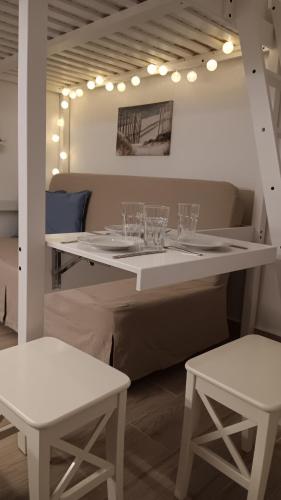 a white table with wine glasses on top of it at Stilvi Milos in Plaka Milou