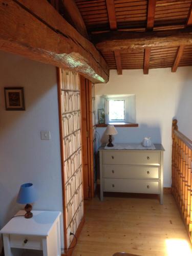 Cette chambre comprend une chambre avec une commode et une fenêtre. dans l'établissement Le four à pain, à Fenioux