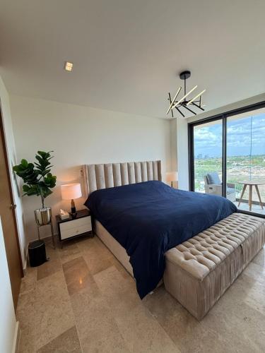 1 dormitorio con 1 cama grande y colcha azul en New luxury apartment, en Mérida