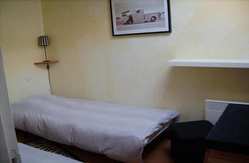 une chambre avec un lit et une photo d'une voiture sur le mur dans l'établissement GITE en LANGUEDOC, à Roquebrun