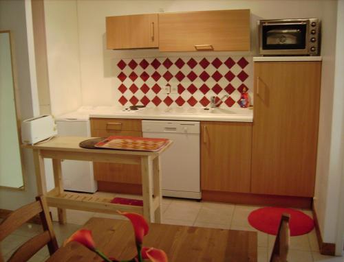 une petite cuisine avec une petite table et un évier dans l'établissement GITE en LANGUEDOC, à Roquebrun