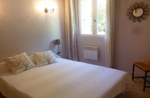 une chambre avec un lit blanc avec une fenêtre dans l'établissement GITE en LANGUEDOC, à Roquebrun