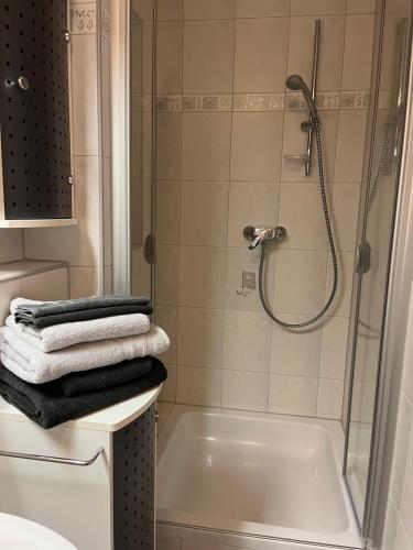 a bathroom with a shower and a bath tub with towels at Lovely Souterrain Apartment in Solingen