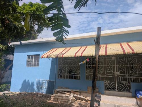 a blue house with a yellow and red awning at TwentyFive at Tower Isle in Tower Isle