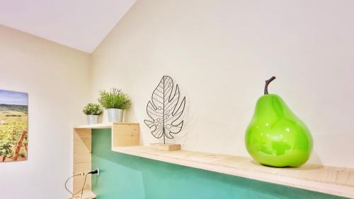 une poire verte posée sur une étagère dans une pièce dans l'établissement Splendide Studio Centre Colmar, à Colmar