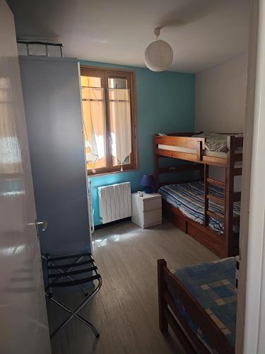 Cette chambre comprend une chambre avec des lits superposés et une fenêtre. dans l'établissement Joli appartement près plage deux chambres quatre personnes, à La Celle-sous-Gouzon