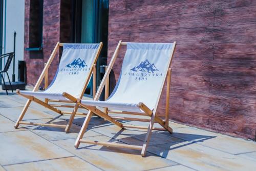 two folding chairs sitting next to each other on a patio at Willa Jaworzynka 1103 K Istebnej in Jaworzynka