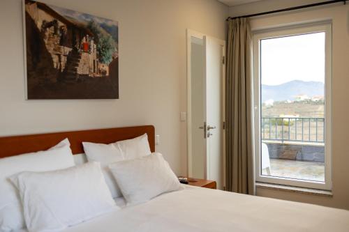 a bedroom with a bed and a large window at Villa Julieta in Ferreiros de Avões