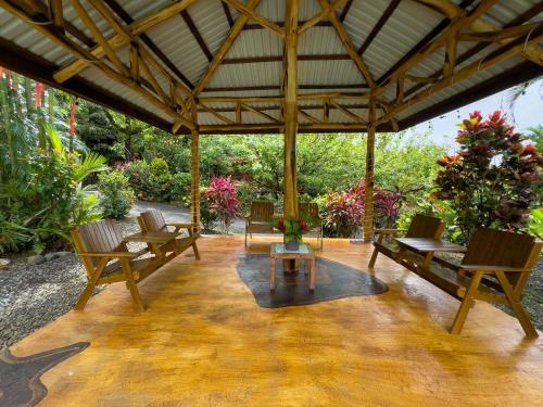 a pavilion with chairs and a table on a patio at Hotel Heliconias Nature Inn & Hot Springs in Fortuna
