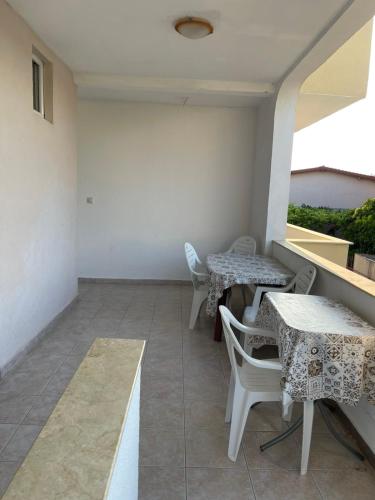Un balcón con mesas y sillas en un edificio. en Apartmani Arieta, en Donji Štoj
