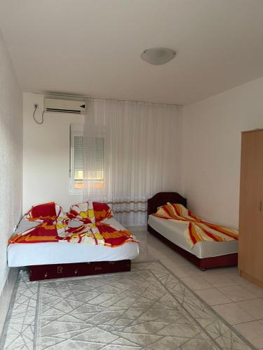 Un dormitorio con dos camas en una habitación. en Apartmani Arieta, en Donji Štoj