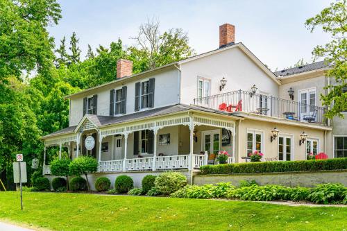 a large white house with a porch at The Old Bank House in Niagara on the Lake