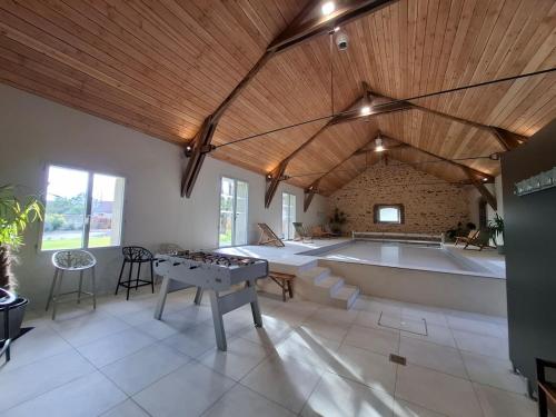 Cette grande chambre comprend une table de ping-pong. dans l'établissement La Grange Flor'Alie gîte et piscine intérieure, à Meslay-le-Grenet