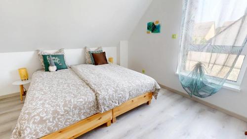 a bedroom with a bed and a window at Maison spacieuse et moderne Strasbourg in Ostwald