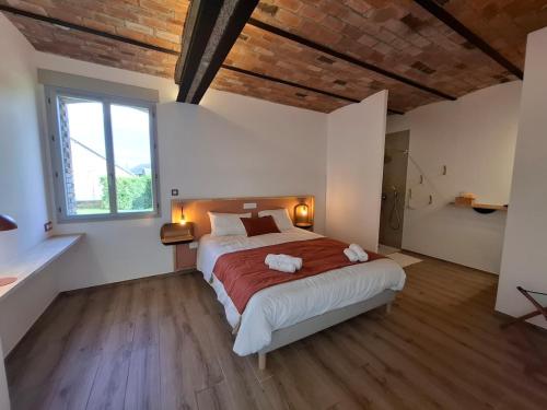 une chambre avec un grand lit et une grande fenêtre dans l'établissement La Grange Flor'Alie gîte et piscine intérieure, à Meslay-le-Grenet