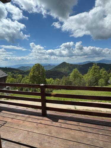 a wooden deck with a view of the mountains at Brvnara Jevtic, Tara in Mokra Gora
