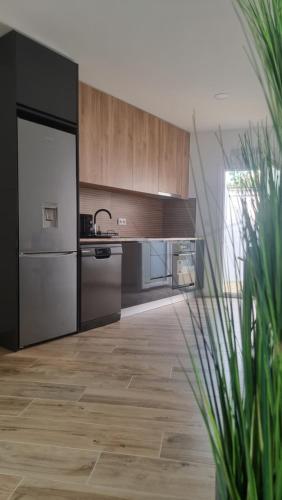 a kitchen with stainless steel appliances and wooden cabinets at Apartamentos Porta do Vez Centro Histórico Moderno in Arcos de Valdevez