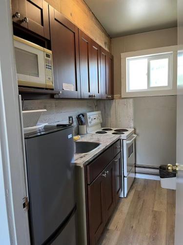 a kitchen with stainless steel appliances and wooden cabinets at Rondo Motel in Golden