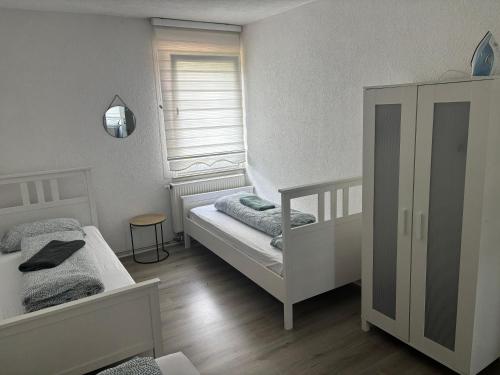 a small bedroom with two beds and a window at Ferien - Wohnung In Kassel Waldau Zentral in Kassel