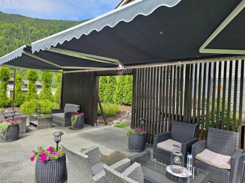 a patio with chairs and a black umbrella at Dalen studio 3 in Dalen