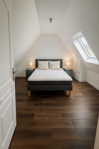 une chambre avec un lit dans un grenier dans l'établissement Maison de campagne, à Ploëzal