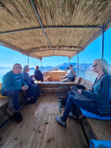 a group of people sitting in the back of a boat at Apartments Stella in Virpazar