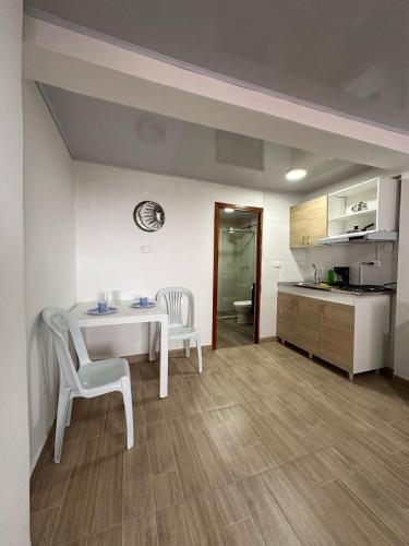 a room with a table and chairs and a kitchen at Apartaestudios Santa Ana in Ruiosucio