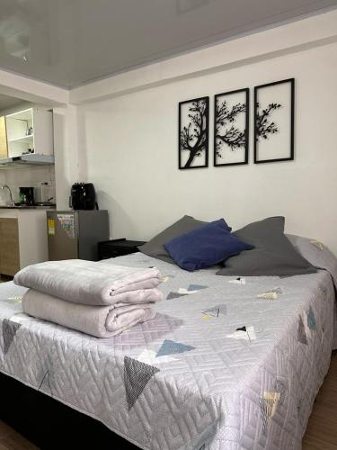 a bedroom with a bed with four pictures on the wall at Apartaestudios Santa Ana in Ruiosucio