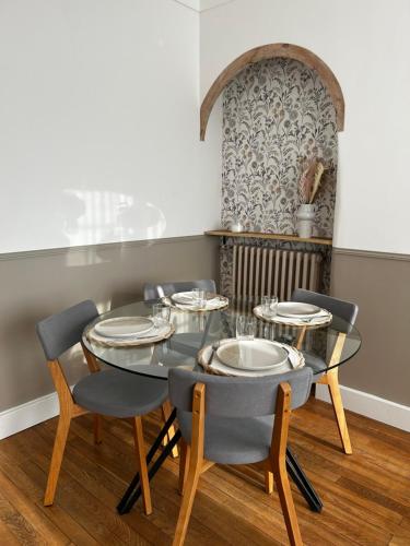 une salle à manger avec une table et des chaises en verre dans l'établissement Le nid marin, à Saint-Nazaire