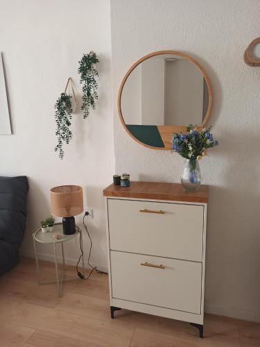 - une commode avec un miroir au-dessus dans l'établissement Charmant T2 centre historique, à Perpignan