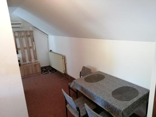 Vrnjačka BanjaにあるApartman Kaćaのテーブルと椅子2つと黒板のある部屋