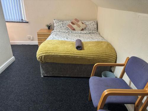 a bedroom with a large bed with two chairs at Simple Lodge in Wakefield