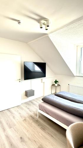 a bedroom with a bed and a flat screen tv at Suite Toni in Neuwied