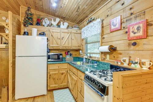 a kitchen with wooden cabinets and a white refrigerator at 11 Mi to Dtwn Franklin Cabin with Porch! in Franklin