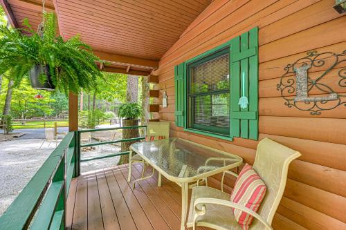 a porch with a table and chairs on a deck at 11 Mi to Dtwn Franklin Cabin with Porch! in Franklin