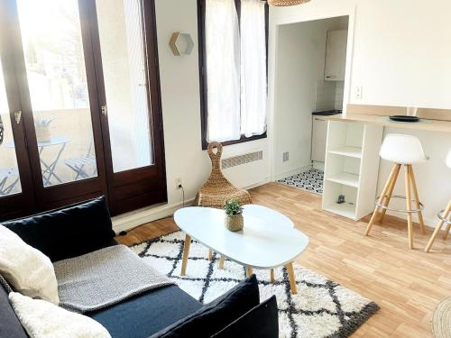 un salon avec un canapé et une table dans l'établissement Nid cosy centre-ville parking inclus, à Toulouse