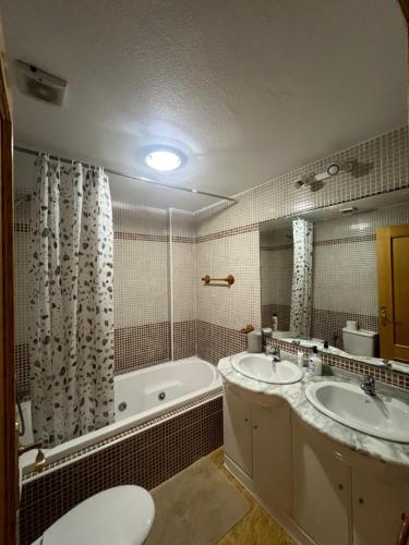 a bathroom with two sinks and a tub and a toilet at Amanecer en la Costa in Villamartin