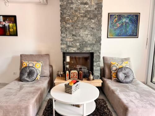 un soggiorno con due divani e un camino di Villa Tatjana Apartments a Struga