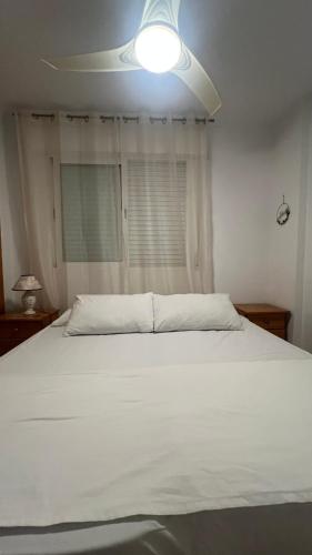 a white bed with a light on top of it at Amanecer en la Costa in Villamartin