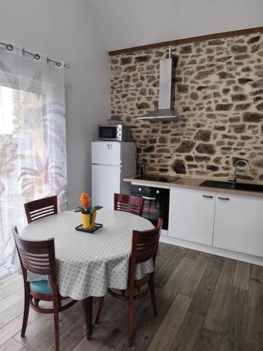 une cuisine avec une table et des chaises dans une pièce dans l'établissement Les petits gites Ernée, à Ernée