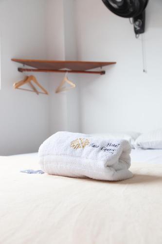 a stack of towels sitting on a bed at Hotel Plaza Centro Cocorná in Cocorná