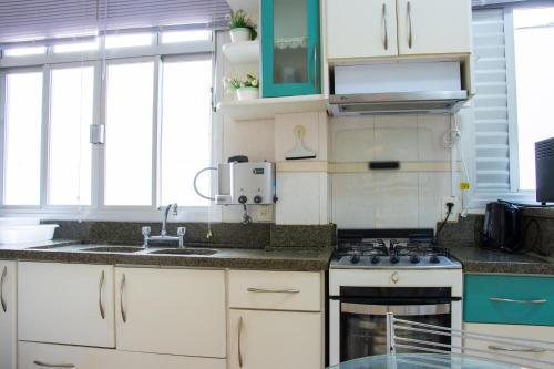 巴拉奈里奥-坎布里乌Apartamento no centro, bem localizado, na praia的带水槽和炉灶的厨房 顶部烤箱