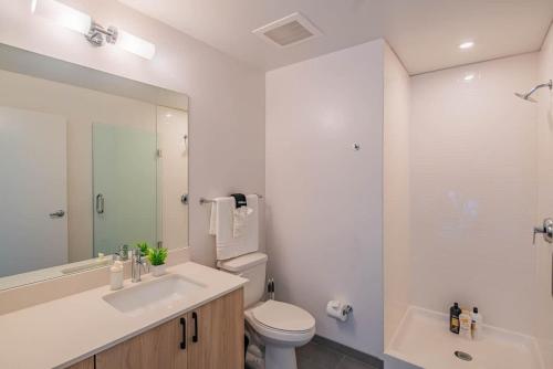 a bathroom with a sink and a toilet and a mirror at Detailed 2BD, HighRise DT, Pool, Gym, Parking, Sleeps 5 in Phoenix