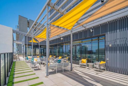 a patio with chairs and tables on a building at Detailed 2BD, HighRise DT, Pool, Gym, Parking, Sleeps 5 in Phoenix