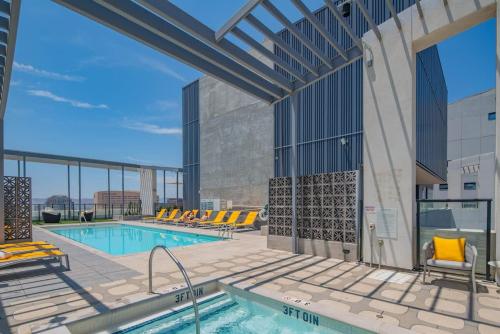 a swimming pool with yellow lounge chairs next to a building at Detailed 2BD, HighRise DT, Pool, Gym, Parking, Sleeps 5 in Phoenix
