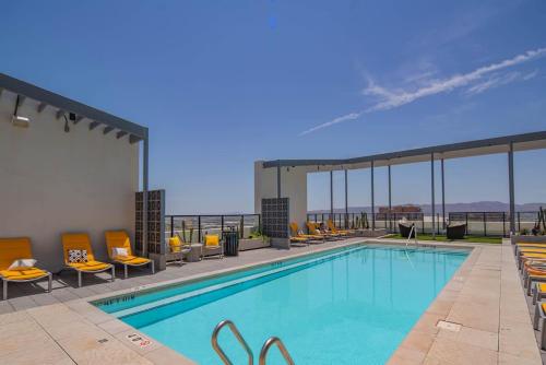 a pool at a hotel with chairs and tables at Detailed 2BD, HighRise DT, Pool, Gym, Parking, Sleeps 5 in Phoenix
