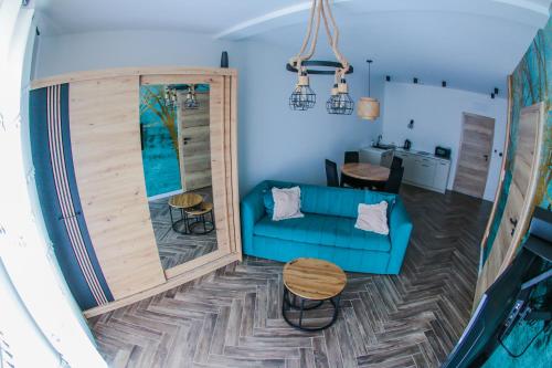 a living room with a blue couch and a table at Willa Jaworzynka 1103 K Istebnej in Jaworzynka
